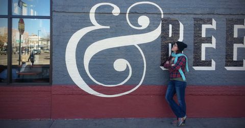 Sondra looks at large ampersand symbol painted on building exterior